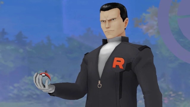 A man in a dark outfit holding a Pokéball.